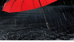 Waterproof red canopy of automatic folding umbrella shown in heavy rain background
