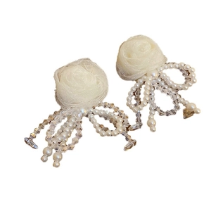 Elegant white floral tassel earrings with faux pearls and beads on a clean white background