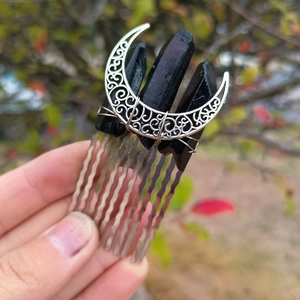 Detail of silver moon hair comb with raw black crystal stones on a metal wavy hairpin base