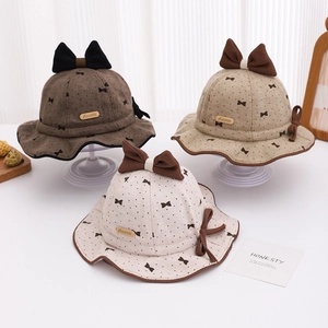 Detailed close-up of brown and beige baby sun hats with bows and polka dot patterns