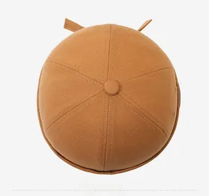 Top-down view of a caramel canvas miki hat showing six-panel crown and button detail