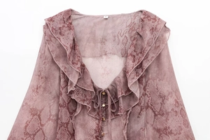 Detail of pink snake print blouse showing ruffled V-neck and delicate golden buttons