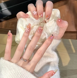 Detail of tulip press-on nails with 3D floral accents and sparkling rhinestone charms