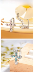 Close-up of cross drop earrings with marquise-cut pink and blue zircon stones