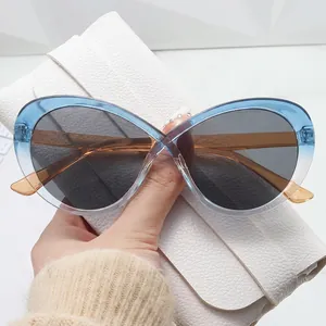 Occhiali da sole cat-eye bicolore con montatura ambra e blu e lenti grigio scuro eleganti