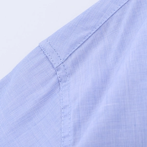 Macro shot of light blue striped shirt fabric texture and professional stitching details