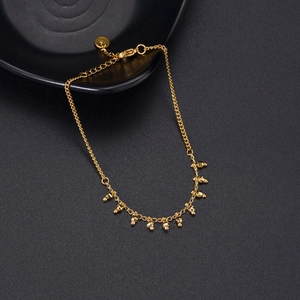 Detailed macro view of 14K gold beaded bracelet with lobster clasp and extension chain