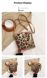 Detail view of stylish leopard print bucket bag with brown trim and golden metal clasp
