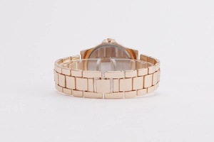 Detailed back view of rose gold metal watch band with smooth polished case back