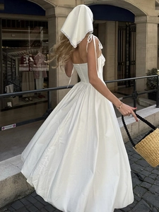 Robe midi blanche en coton à bretelles avec jupe volumineuse dans une rue à la française