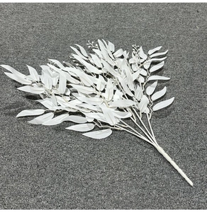 Detail view of artificial white willow leaf branches on a textured grey background