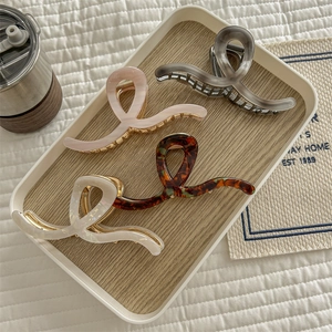 Elegant acetate shark hair clips in pink, grey, amber, and beige for thick hair styling