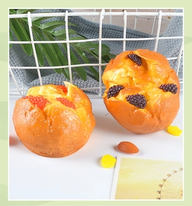 Detail of artificial bread models with berry toppings on a white surface for decor
