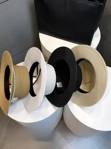 Detail of multi-color woven straw hats with pearl bow and sweatband on display stands