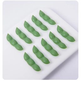 Top view of ten realistic miniature PVC edamame models arranged on a white background