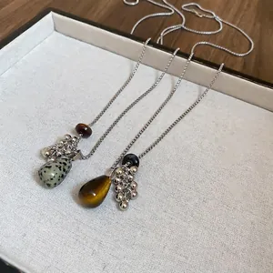 Tiger eye stone tassel pendant necklace with silver bead accents on elegant display