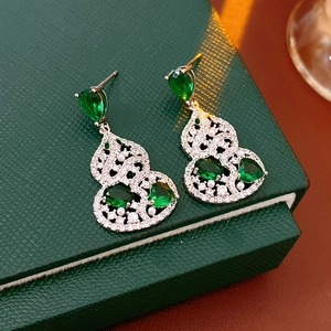 Detail of silver gourd earrings with emerald green stones and sparkling cubic zirconia