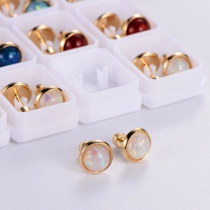 Golden round opal earrings with rainbow finish in a white jewelry gift box set