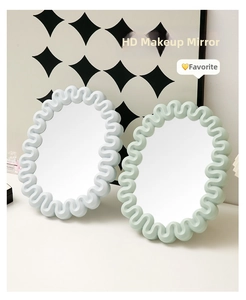 Close-up of wavy frame desktop makeup mirrors in soft blue and pale green colors