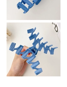Detailed view of a solid blue resin hair claw clip with strong teeth for secure hairstyling