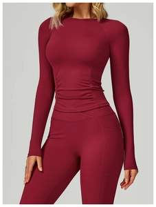 Détail du haut de yoga bordeaux avec fronces latérales et legging avec poches latérales