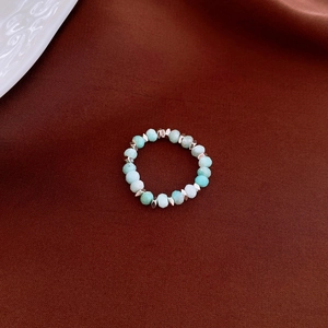 Detailed macro view of amazonite gemstone beads and silver metal spacers on a beaded ring