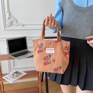 Detail of warm brown corduroy tote bag with Keep Smiling print and metal snap button closure