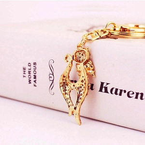 Elegant gold cat keychain with crystal rhinestones on a white book background