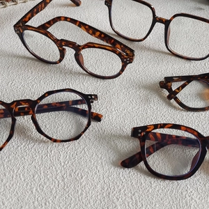 Flat lay view of various tortoiseshell eyewear frames in multiple geometric shapes