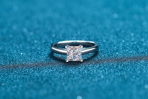 Macro shot of S925 sterling silver ring featuring a princess cut moissanite in 4-prong setting