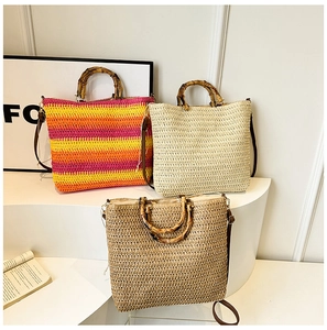 Straw tote bags with bamboo handles in colorful stripes and beige on a white display
