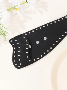 Detail eines schwarzen Punk-Ledergürtels mit Nieten, Wellenkanten und Druckknöpfen