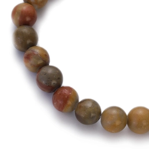 Macro shot of colorful natural stone beads in reddish brown and olive green on a white base