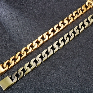 Close-up of gold and antique silver Cuban link bracelets on a textured leather background