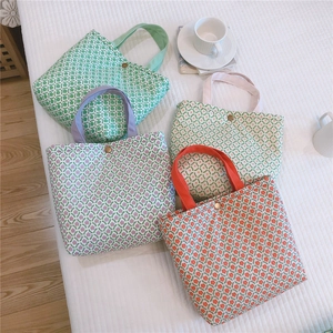 Close-up of four floral canvas tote bags with snap buttons in green and pink colors