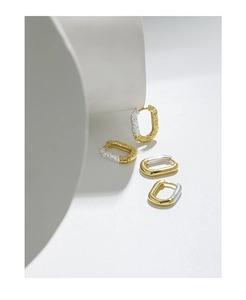 Detailed view of U-shaped sterling silver earrings featuring smooth and lava textured finishes