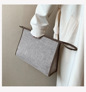 Détail du sac de bureau en toile grise avec bordure en cuir marron et fermeture éclair