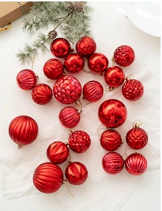Coffret de boules de Noël rouges aux textures mates et brillantes sur tissu blanc