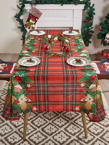 Close-up of red plaid Christmas tablecloth with holly and gingerbread house patterns