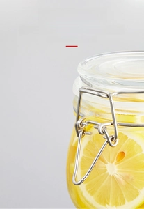 Detail of transparent glass jar with stainless steel buckle lid and lemon slices