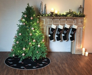Knitted black Christmas stocking and tree skirt set with white snowflake and candy cane patterns
