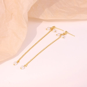 Close-up of elegant S925 silver golden chain tassel earrings with white pearls