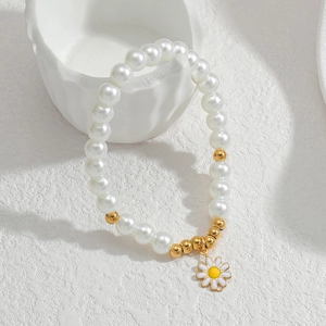 Minimalist pearl daisy bracelet with stainless steel beads on a white textured background