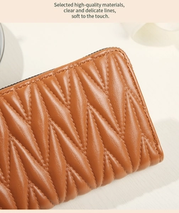 Macro view of brown quilted leather texture with wavy stitching on a large clutch wallet