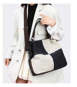 Detail of checkered canvas tote bag with adjustable woven shoulder strap on model