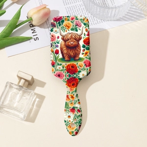 Dettaglio della spazzola per capelli con stampa di mucca Highland e fiori su sfondo chiaro