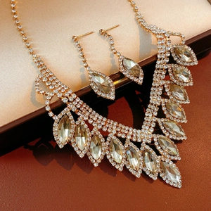 Close-up of elegant gold tassel necklace and earrings set with marquise rhinestones