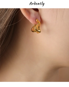 Close-up of gold irregular lava-style titanium earrings on a female model