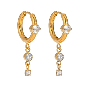 Detail of gold titanium steel earrings with crystal zircon pendants and tassel chains