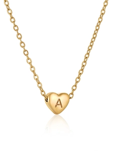 Détail d'un collier pendentif cœur doré avec une lettre A majuscule gravée
